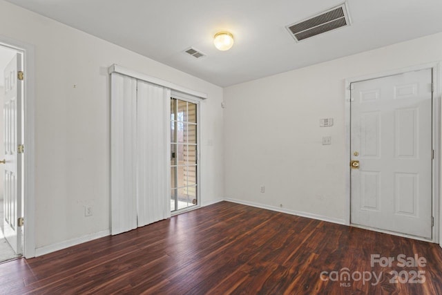 unfurnished room featuring a wealth of natural light, visible vents, and wood finished floors