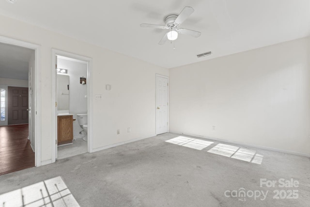 unfurnished bedroom featuring visible vents, baseboards, carpet flooring, and ensuite bathroom