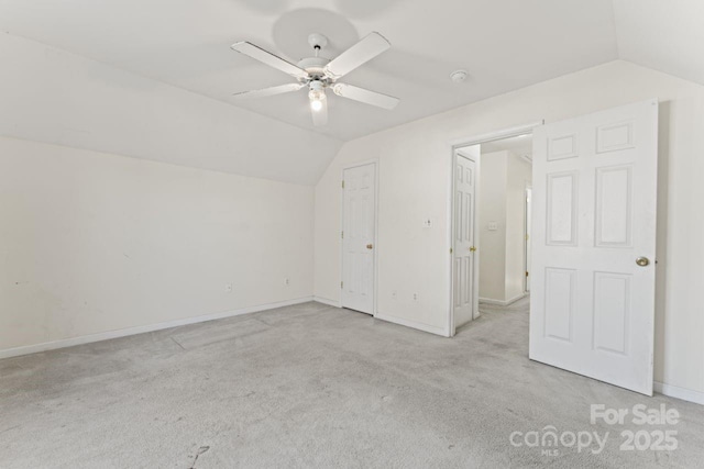 interior space with carpet floors, baseboards, and vaulted ceiling