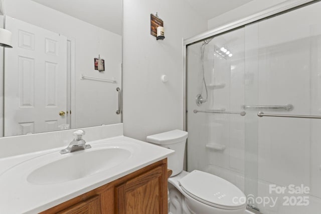 full bathroom featuring toilet, a shower stall, and vanity