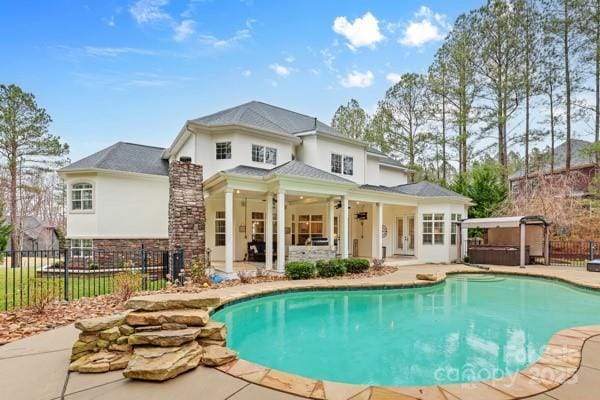 view of swimming pool with a fenced in pool, a patio area, fence, and a hot tub