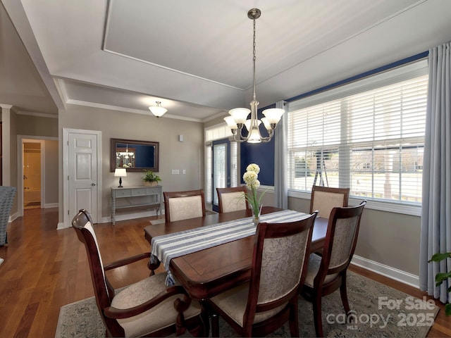 dining room featuring a wealth of natural light, crown molding, and wood finished floors