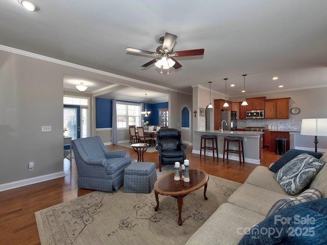 living room featuring recessed lighting, dark wood-style flooring, a ceiling fan, baseboards, and crown molding