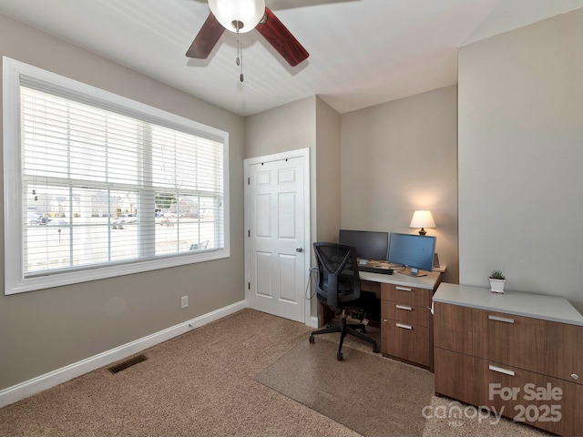 carpeted office with baseboards, visible vents, and ceiling fan