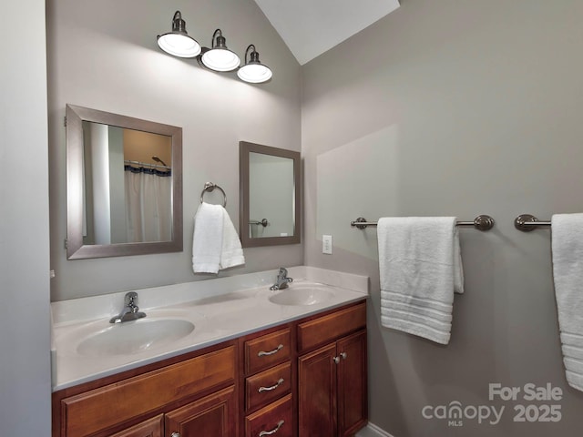 bathroom featuring vaulted ceiling, double vanity, and a sink