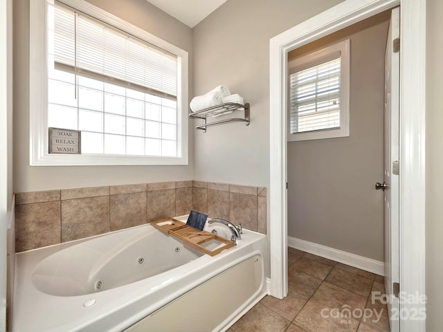 full bathroom featuring a whirlpool tub, plenty of natural light, baseboards, and tile patterned floors