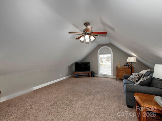 carpeted living area with vaulted ceiling and baseboards