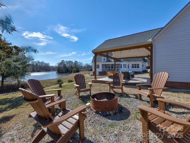 view of patio with an outdoor fire pit and a water view