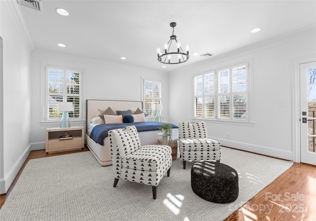 bedroom with crown molding, visible vents, and wood finished floors