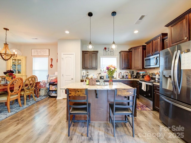 kitchen featuring appliances with stainless steel finishes, a wealth of natural light, and light wood finished floors