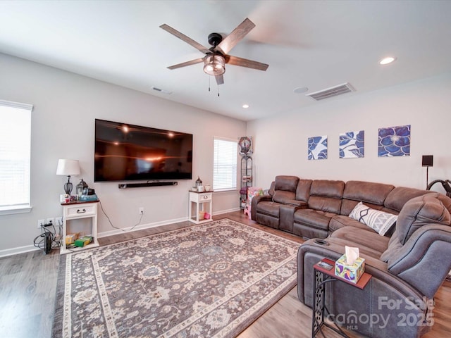 living area featuring baseboards, visible vents, wood finished floors, and recessed lighting