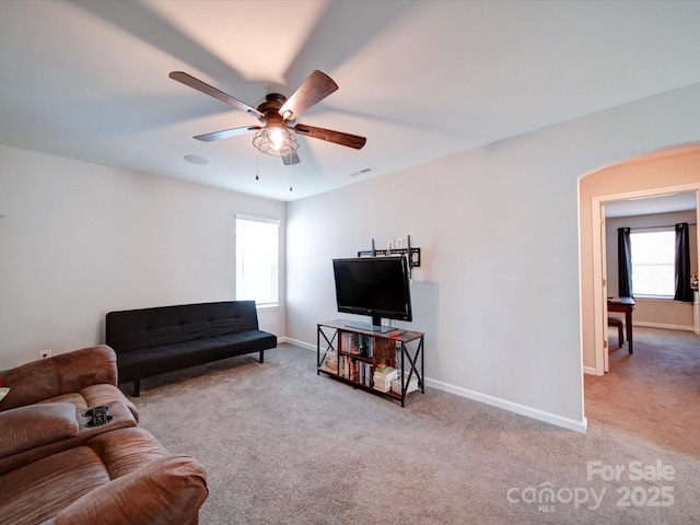 living room with carpet flooring, ceiling fan, visible vents, and baseboards