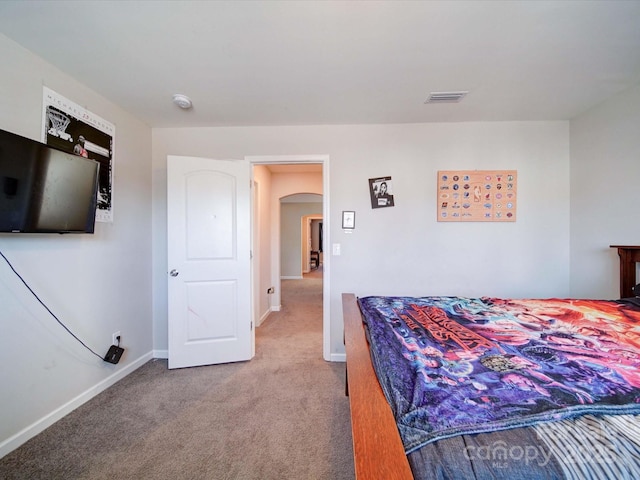 bedroom featuring baseboards, visible vents, arched walkways, and carpet flooring