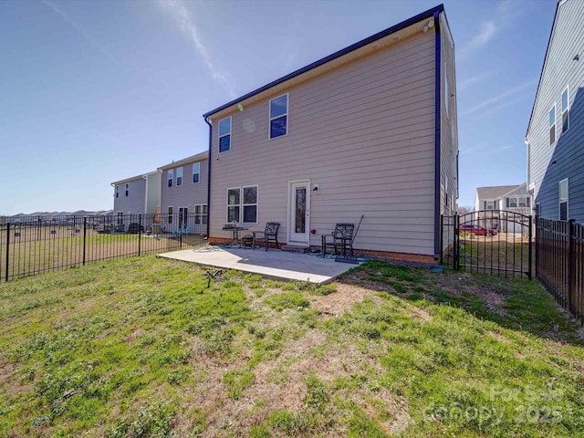 rear view of property featuring a fenced backyard, a patio, and a lawn