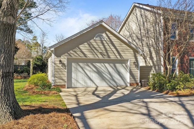 exterior space featuring a garage, cooling unit, and driveway