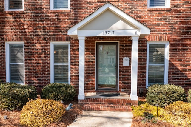 property entrance featuring brick siding