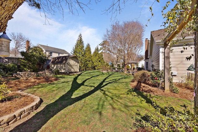 view of yard featuring an outbuilding, a storage unit, and fence