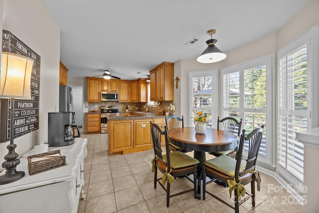 dining space featuring a ceiling fan, visible vents, and light tile patterned floors