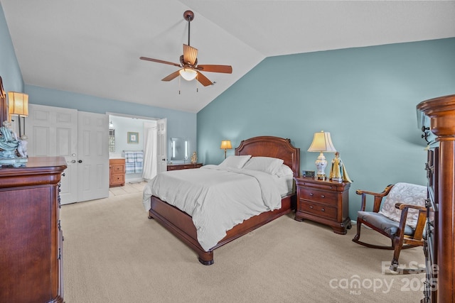 bedroom featuring vaulted ceiling, ceiling fan, connected bathroom, and light colored carpet