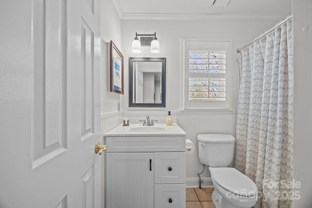 full bathroom with toilet, vanity, ornamental molding, wainscoting, and tile patterned floors