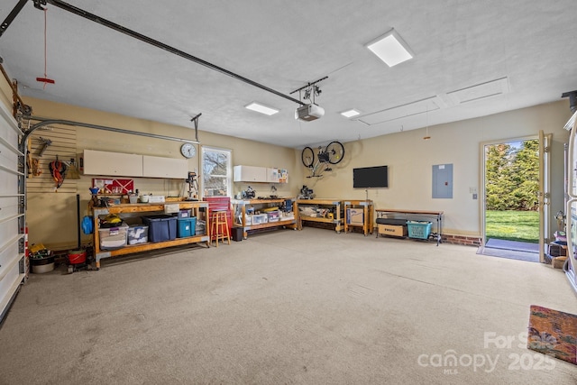 garage with a workshop area, electric panel, and a garage door opener