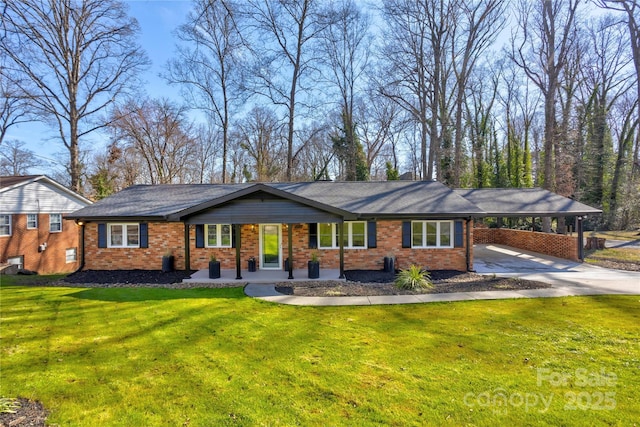 view of front of house with concrete driveway, an attached carport, a front yard, and brick siding