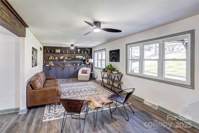 living area with dark wood-style flooring, visible vents, baseboards, and a bar