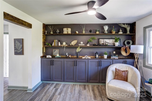 bar featuring baseboards, light wood-style flooring, and a ceiling fan