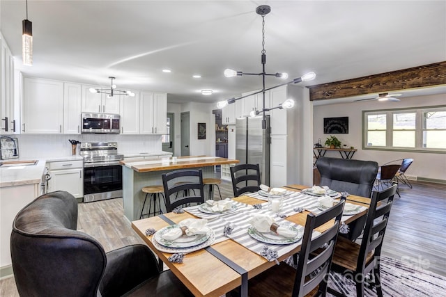 dining space featuring light wood-style floors and a ceiling fan