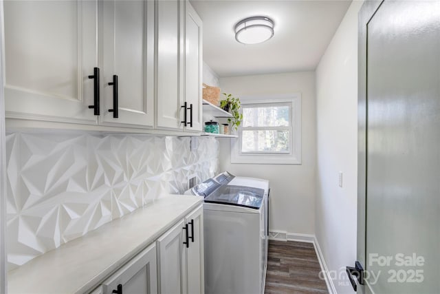 washroom with dark wood-style floors, baseboards, cabinet space, and washer and dryer