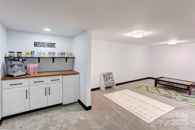 interior space featuring light carpet and baseboards