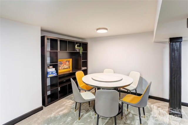 dining room with baseboards and light colored carpet