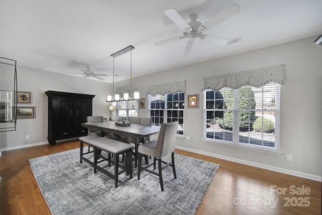 dining room featuring visible vents, wood finished floors, a ceiling fan, and baseboards