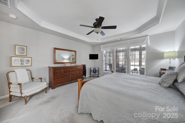 carpeted bedroom featuring baseboards, visible vents, a ceiling fan, ornamental molding, and a tray ceiling