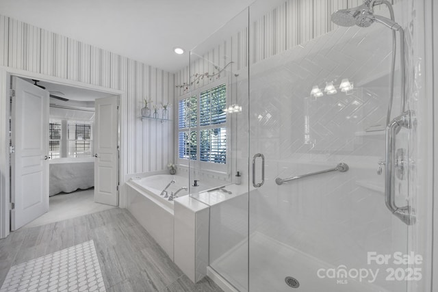 bathroom with a stall shower, a garden tub, ensuite bath, and wallpapered walls