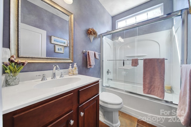 bathroom with tile patterned flooring, vanity, toilet, and bath / shower combo with glass door