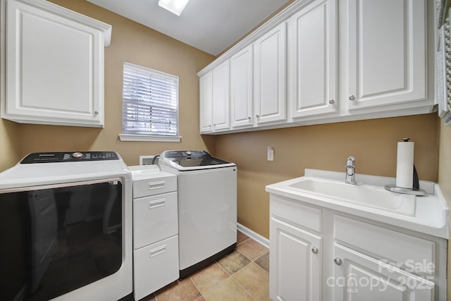 laundry area with cabinet space, baseboards, a sink, and independent washer and dryer