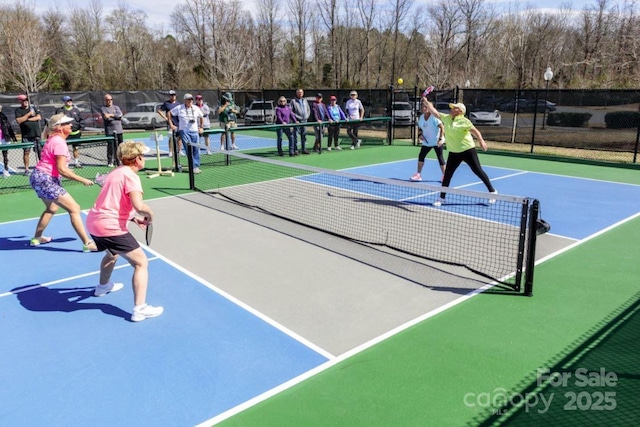 view of tennis court featuring fence