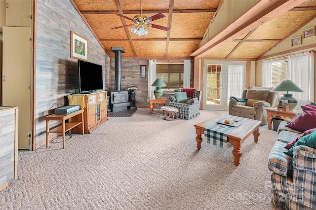 193 Oak Ridge Rd, Hendersonville, NC 28792 - living room featuring a wood stove, carpet flooring, vaulted ceiling, and ceiling fan