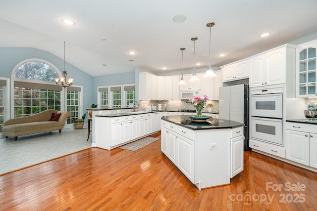 kitchen featuring dark countertops, white cabinetry, and hanging light fixtures