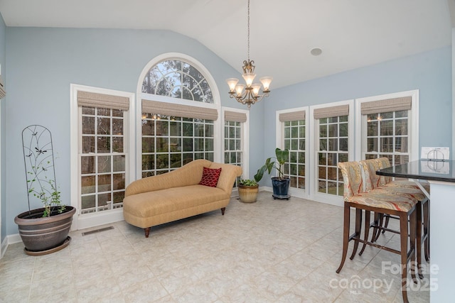 sunroom / solarium with lofted ceiling, visible vents, and a notable chandelier