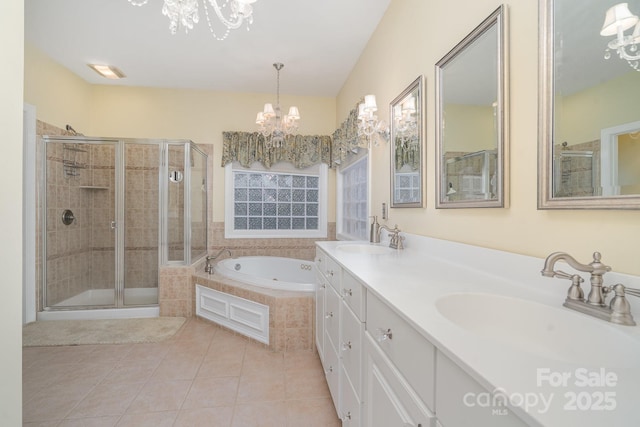 full bath with a sink, tile patterned flooring, a tub with jets, and a notable chandelier