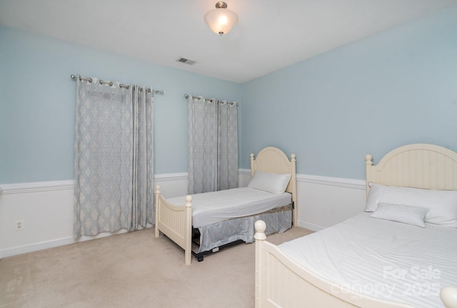 bedroom with light colored carpet, visible vents, and baseboards