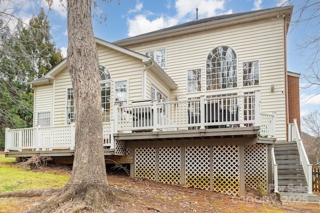 rear view of house featuring stairway and a deck