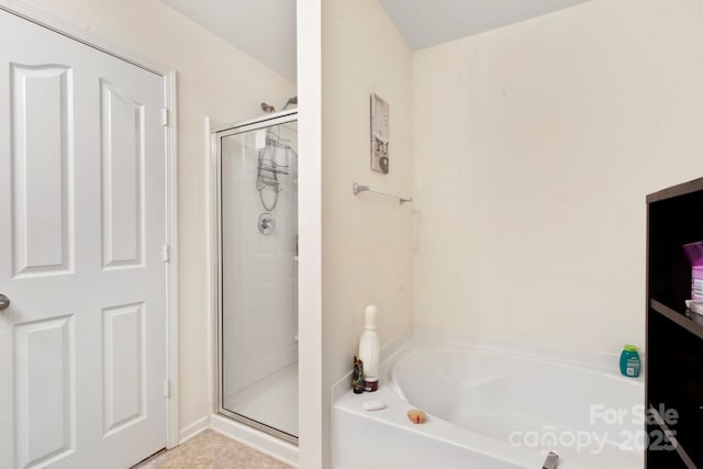 bathroom with a shower stall and a garden tub