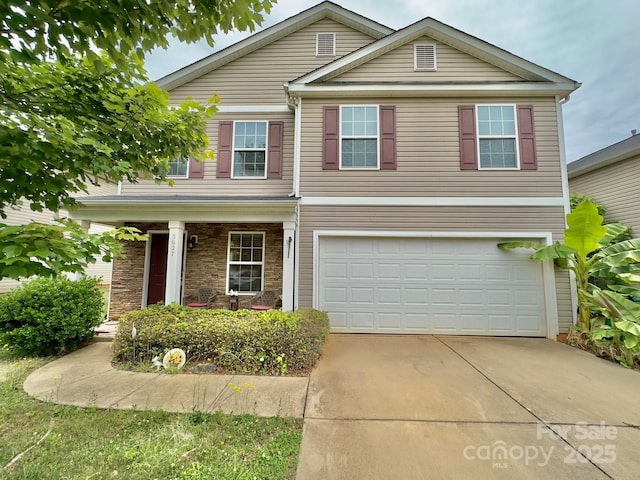 traditional home with an attached garage, driveway, and a porch