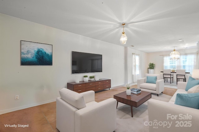 living room with baseboards and a chandelier