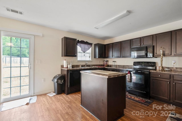 kitchen with black appliances, light wood-type flooring, and dark brown cabinets