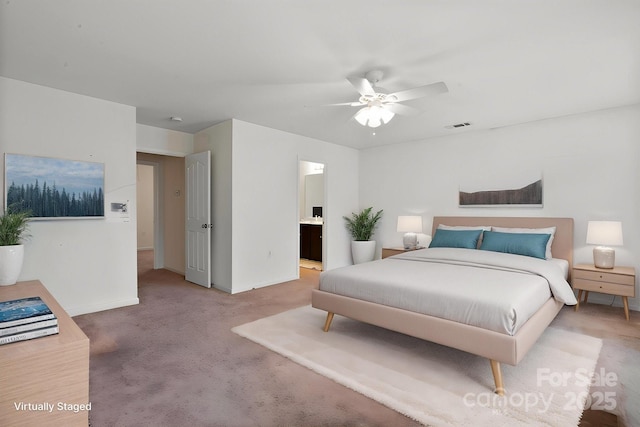 bedroom featuring baseboards, carpet flooring, ensuite bath, and a ceiling fan