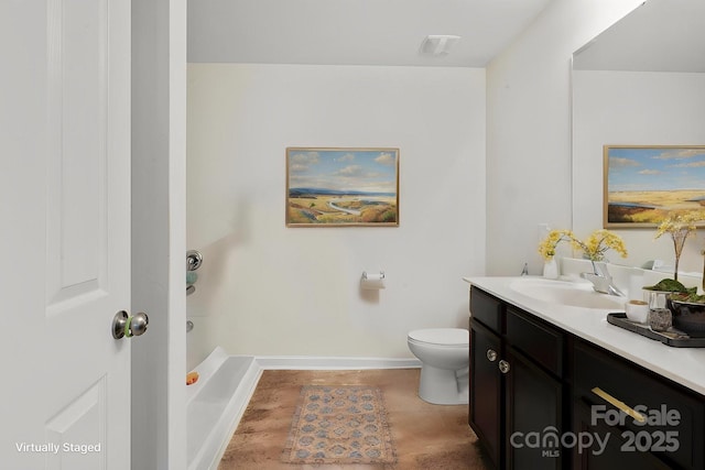 bathroom with vanity, toilet, and baseboards